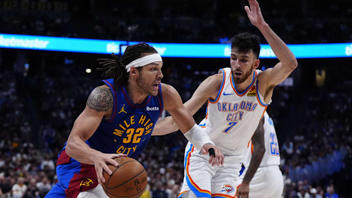 May 9, 2025; Denver, Colorado, USA; Denver Nuggets forward Aaron Gordon (32) drives at Oklahoma City Thunder forward Chet Holmgren (7) in the second half during game three of the second round for the 2025 NBA Playoffs at Ball Arena. Mandatory Credit: Ron Chenoy-Imagn Images