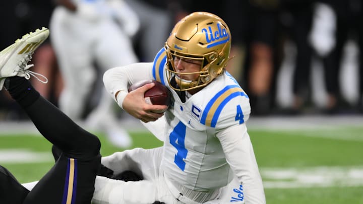 Nov 15, 2024; Seattle, Washington, USA; Washington Huskies defensive lineman Russell Davis II (99) sacks UCLA Bruins quarterback Ethan Garbers (4) during the first half at Alaska Airlines Field at Husky Stadium. Mandatory Credit: Steven Bisig-Imagn Images