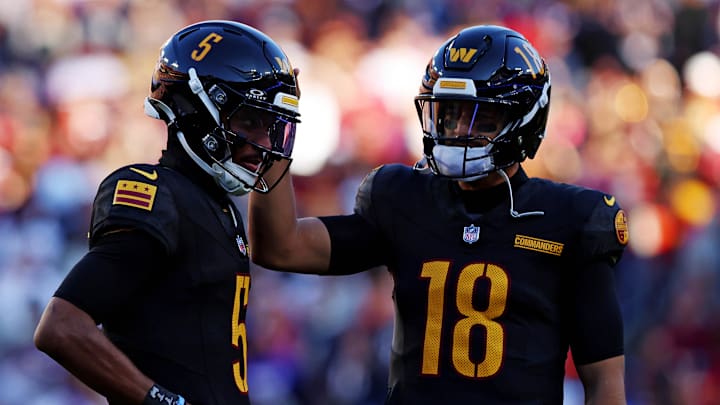 Oct 27, 2024; Landover, Maryland, USA; Washington Commanders quarterback Jayden Daniels (5) and quarterback Marcus Mariota (18) talk to each other during the first half against the Chicago Bears at Commanders Field. Mandatory Credit: Peter Casey-Imagn Images