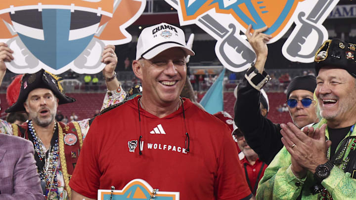 Dec 19, 2025; Tampa, FL, USA; NC State Wolfpack head coach Dave Doeren receives the trophy after beating Memphis Tigers in the Gasparilla Bowl at Raymond James Stadium. Mandatory Credit: Nathan Ray Seebeck-Imagn Images