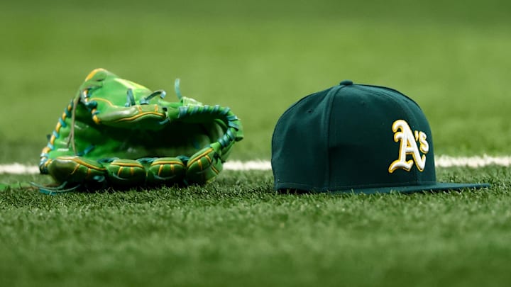 Jul 22, 2025; Arlington, Texas, USA;  Athletics glove and hat on the field before the game against the Texas Rangers at Globe Life Field. Mandatory Credit: Kevin Jairaj-Imagn Images