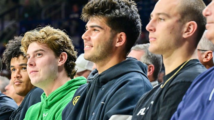 Nov 11, 2024; South Bend, Indiana, USA; Notre Dame football quarterbacks (from left to right) Riley Leonard, Kenny Minchey, Steve Angeli, Anthony Rezac and CJ Carr watch in the first half of the basketball game between the Notre Dame Fighting Irish and the Buffalo Bulls at the Purcell Pavilion. 