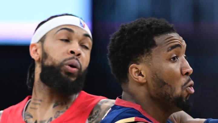 Cleveland Cavaliers guard Donovan Mitchell passes while being defended by Toronto Raptors forward Brandon Ingram