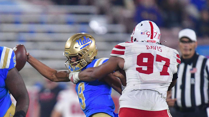 Nov 8, 2025; Pasadena, California, USA; UCLA Bruins quarterback Nico Iamaleava (9) is sacked by Nebraska Cornhuskers defensive lineman Keona Davis (97) during the second half at the Rose Bowl. Mandatory Credit: Gary A. Vasquez-Imagn Images
