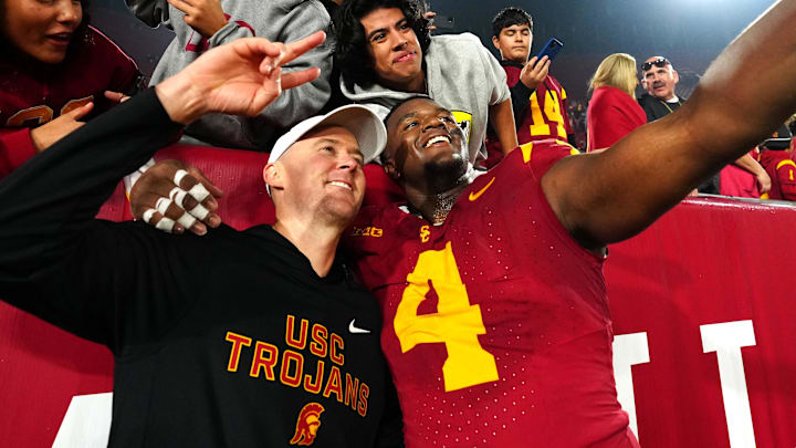 Nov 29, 2025; Los Angeles, California, USA; Southern California Trojans head coach Lincoln Riley (right) and defensive tackle Jahkeem Stewart (4) pose with fans after the game against the UCLA Bruins at United Airlines Field at Los Angeles Memorial Coliseum. Mandatory Credit: Kirby Lee-Imagn Images Nov 29, 2025; Los Angeles, California, USA; Southern California Trojans head coach Lincoln Riley (right) and defensive tackle Jahkeem Stewart (4) pose with fans after the game against the UCLA Bruins at United Airlines Field at Los Angeles Memorial Coliseum. Mandatory Credit: Kirby Lee-Imagn Images