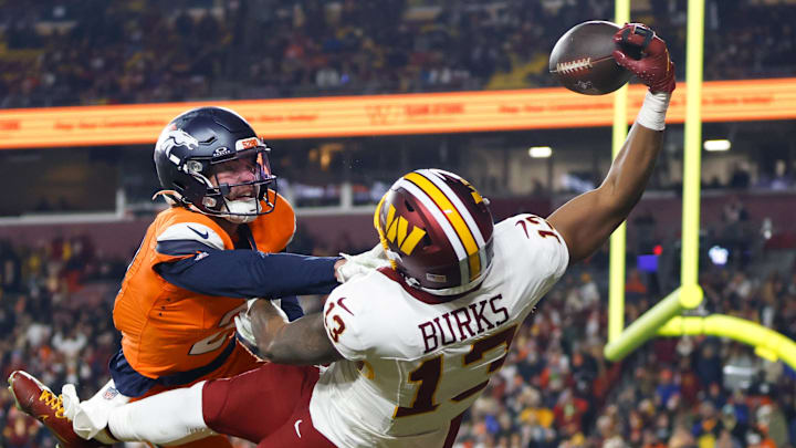 Washington Commanders wide receiver Treylon Burks (13) makes a catch for a touchdown defended by Denver Broncos cornerback Riley Moss (21) in the third quarter of the game at Northwest Stadium.
