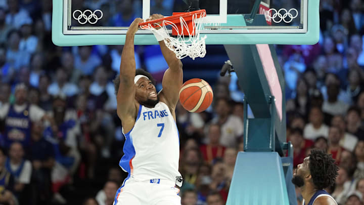 Aug 10, 2024; Paris, France; France power forward Guerschon Yabusele (7) dunks against United States guard Devin Booker (15) and centre Joel Embiid (11) in the first quarter in the men's basketball gold medal game during the Paris 2024 Olympic Summer Games at Accor Arena. Mandatory Credit: Kyle Terada-Imagn Images