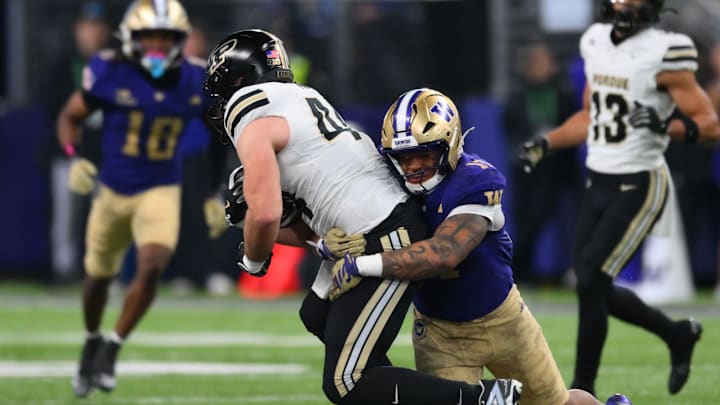 Nov 15, 2025; Seattle, Washington, USA; Washington Huskies linebacker Deven Bryant (17) tackles Purdue Boilermakers tight end Christian Moore (44) during the second half at Husky Stadium. Mandatory Credit: Steven Bisig-Imagn Images