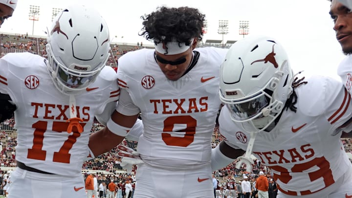 Texas Longhorns defensive backs Xavier Filsaime, Jonah Williams and Jordon Johnson-Rubell huddle up during warm ups prior to the game against the Mississippi State Bulldogs at Davis Wade Stadium at Scott Field. 