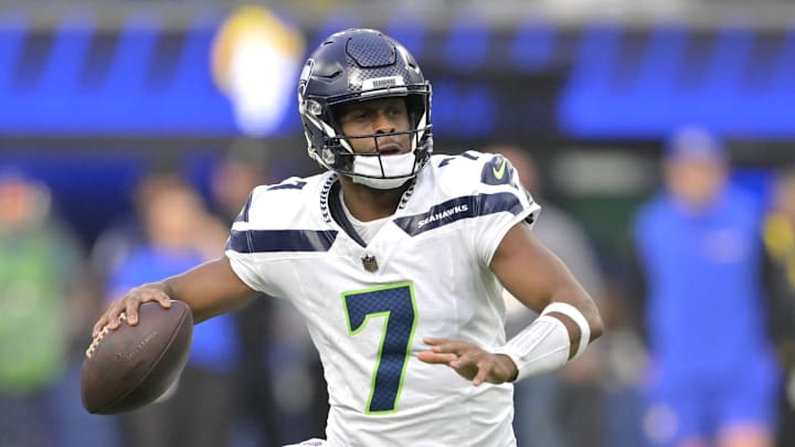 Jan 5, 2025; Inglewood, California, USA; Seattle Seahawks quarterback Geno Smith (7) scrambles away from Los Angeles Rams linebacker Byron Young (0) and throws for a touchdown in the first half at SoFi Stadium. Mandatory Credit: Jayne Kamin-Oncea-Imagn Images