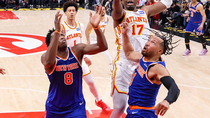 Atlanta Hawks forward Onyeka Okongwu (17) and New York Knicks forward Og Anunoby (8) and guard Jalen Brunson (11) reach for a rebound in the first half during game six of the first round of the 2026 NBA Playoffs at State Farm Arena. 