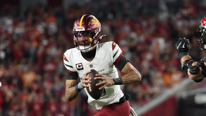 Jan 12, 2025; Tampa, Florida, USA; Washington Commanders quarterback Jayden Daniels (5) scrambles during the second quarter of a NFC wild card playoff against the Tampa Bay Buccaneers at Raymond James Stadium. Mandatory Credit: Nathan Ray Seebeck-Imagn Images