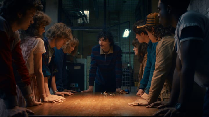 (L to R) Joe Keery as Steve Harrington, Natalia Dyer as Nancy Wheeler, Charlie Heaton as Jonathan Byers, Maya Hawke as Robin Buckley, Finn Wolfhard as Mike Wheeler, Winona Ryder as Joyce Byers, Noah Schnapp as Will Byers, Gaten Matarazzo as Dustin Henderson, and Caleb McLaughlin as Lucas Sinclair in Stranger Things 5