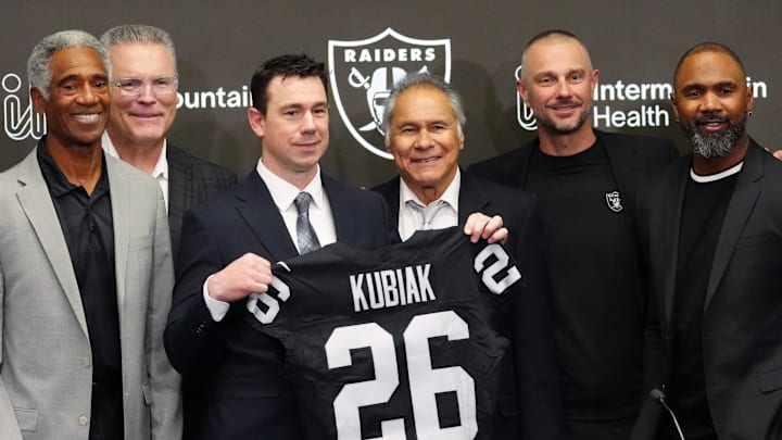 Feb 10, 2026; Henderson, NV, USA; Las Vegas Raiders coach Klint Kubiak (center) poses at introductory press conference at Intermountain Health Performance Center. From left: Marcus Allen, Mike Haynes, Howie Long, Kubiak, general manager John Spyktek, Charles Woodson and Rich Gannon. Mandatory Credit: Kirby Lee-Imagn Images
