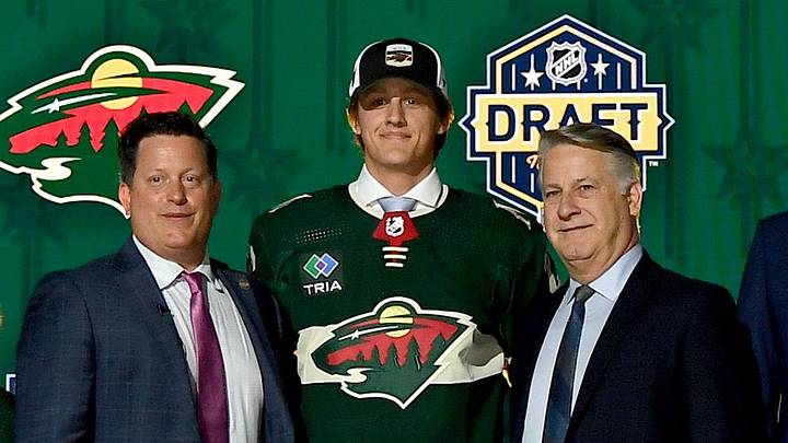 Jun 28, 2023; Nashville, Tennessee, USA; Minnesota Wild draft pick Charlie Stramel stands with Wild staff after being selected with the twenty-first pick in round one of the 2023 NHL Draft at Bridgestone Arena. Mandatory Credit: Christopher Hanewinckel-Imagn Images