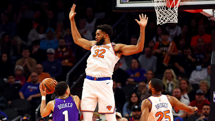 Nov 20, 2024; Phoenix, Arizona, USA; Phoenix Suns guard Devin Booker (1) shoots the ball against New York Knicks center Karl-Anthony Towns (32) during the third quarter at Footprint Center. Mandatory Credit: Mark J. Rebilas-Imagn Images