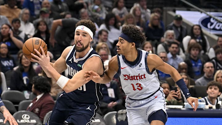 Jan 27, 2025; Dallas, Texas, USA; Dallas Mavericks guard Klay Thompson (31) drives to the basket past Washington Wizards forward Kyle Kuzma (33) and guard Jordan Poole (13) during the first quarter at the American Airlines Center. Mandatory Credit: Jerome Miron-Imagn Images