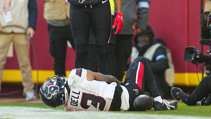 Houston Texans receiver Tank Dell lays on the field after suffering an injury.
