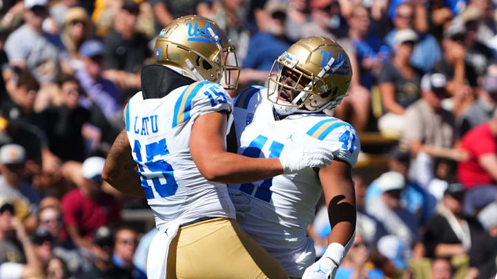Sep 24, 2022; Boulder, Colorado, USA; UCLA Bruins linebacker Laiatu Latu (15) and linebacker Devin Aupiu (41) celebrate a play in the first quarter against the Colorado Buffaloes at Folsom Field. Mandatory Credit: Ron Chenoy-Imagn Images