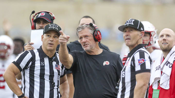 Sep 27, 2025; Morgantown, West Virginia, USA; Utah Utes head coach Kyle Whittingham talks to several officials during the third quarter against the West Virginia Mountaineers at Milan Puskar Stadium. Sep 27, 2025; Morgantown, West Virginia, USA; Utah Utes head coach Kyle Whittingham talks to several officials during the third quarter against the West Virginia Mountaineers at Milan Puskar Stadium.