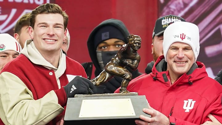 Jan 24, 2026; Bloomington, IN, USA; Indiana Hoosiers quarterback Fernando Mendoza (15) holds the Heisman Trophy with Indiana Hoosiers head coach Curt Cignetti on Saturday, Jan. 24, 2026, during the Indiana Football College Football Playoff National Championship celebration and parade at Memorial Stadium. Mandatory Credit: Grace Hollars-USA TODAY Network via Imagn Images
