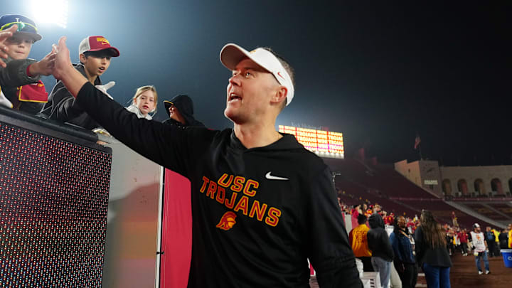 Nov 29, 2025; Los Angeles, California, USA; Southern California Trojans head coach Lincoln Riley celebrates with fans after the game against the UCLA Bruins at United Airlines Field at Los Angeles Memorial Coliseum. Mandatory Credit: Kirby Lee-Imagn Images