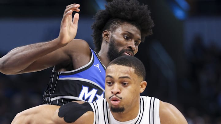 San Antonio Spurs forward Keldon Johnson moves the ball past Orlando Magic forward Jonathan Isaac