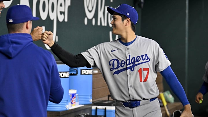 Los Angeles Dodgers designated hitter Shohei Ohtani (17) greets first base coach/infield coach Chris Woodward (84) before the game against the Texas Rangers at Globe Life Field. 