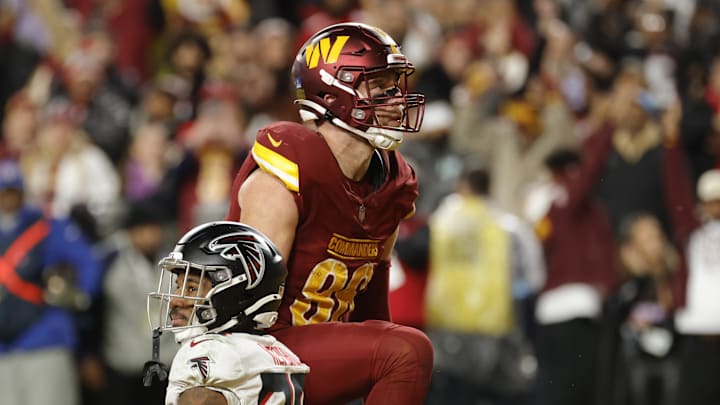 Dec 29, 2024; Landover, Maryland, USA; Washington Commanders tight end Zach Ertz (86) celebrates after scoring the game winning touchdown in front of Atlanta Falcons cornerback Dee Alford (20) during overtime at Northwest Stadium. Mandatory Credit: Amber Searls-Imagn Images
