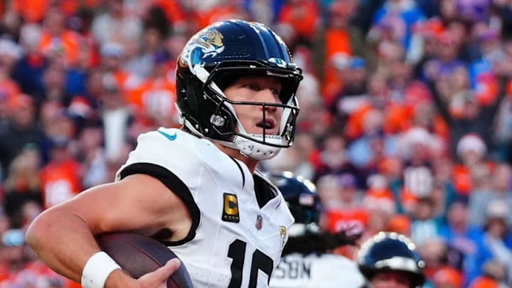 Dec 21, 2025; Denver, Colorado, USA; Jacksonville Jaguars quarterback Trevor Lawrence (16) rushes for a touchdown against the Denver Broncos during the second half at Empower Field at Mile High. Mandatory Credit: Ron Chenoy-Imagn Images