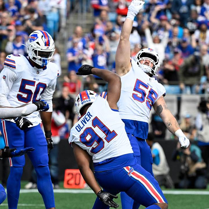 Buffalo Bills DE Greg Rousseau, DT Oliver, and DE Michael Hoecht celebrate after a sack against the Carolina Panthers.
