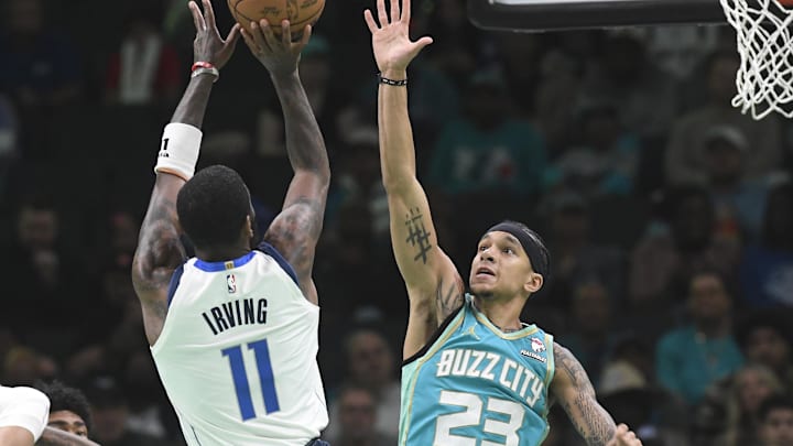 Apr 9, 2024; Charlotte, North Carolina, USA;  Charlotte Hornets guard Tre Mann (23) defends against Dallas Mavericks guard Kyrie Irving (11) during the second half at the Spectrum Center. Mandatory Credit: Sam Sharpe-Imagn Images
