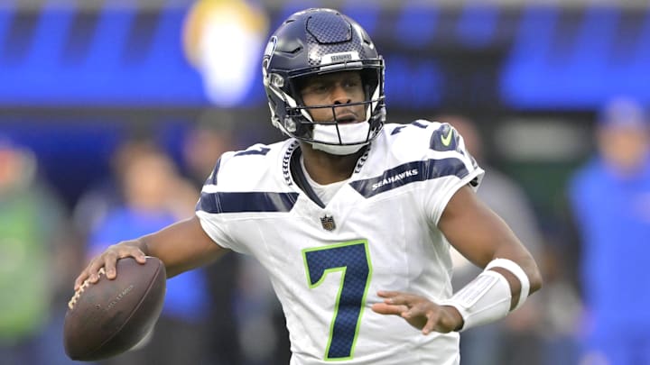 Jan 5, 2025; Inglewood, California, USA; Seattle Seahawks quarterback Geno Smith (7) scrambles away from Los Angeles Rams linebacker Byron Young (0) and throws for a touchdown in the first half at SoFi Stadium. Mandatory Credit: Jayne Kamin-Oncea-Imagn Images