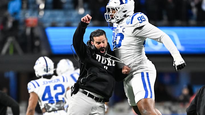 Dec 6, 2025; Charlotte, NC, USA; Duke Blue Devils head coach Manny Diaz reacts with defensive tackle Aaron Hall (99) in the first quarter against the Virginia Cavaliers during the 2025 ACC Championship game at Bank of America Stadium. Mandatory Credit: Bob Donnan-Imagn Images