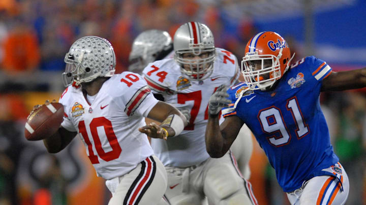 Jan 8, 2007; Glendale, AZ, USA; Ohio State quarterback (10) Troy Smith is pressured by Florida Gators defensive end (91) Derrick Harvey during the BCS National Championship game at the University of Phoenix Stadium. Florida defeated Ohio State 41-14. Mandatory Credit: Mark J. Rebilas-Imagn Images Copyright © 2007 Mark J. Rebilas