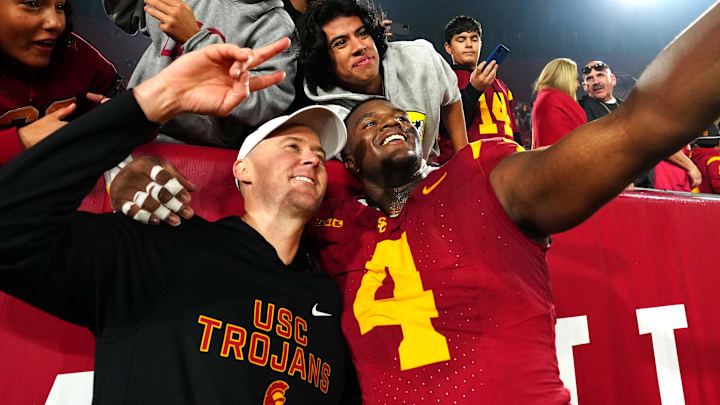Nov 29, 2025; Los Angeles, California, USA; Southern California Trojans head coach Lincoln Riley (right) and defensive tackle Jahkeem Stewart (4) pose with fans after the game against the UCLA Bruins at United Airlines Field at Los Angeles Memorial Coliseum. Mandatory Credit: Kirby Lee-Imagn Images