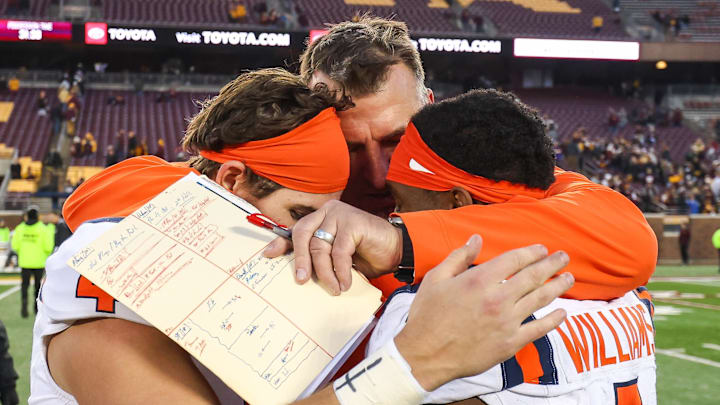 Nov 4, 2023; Minneapolis, Minnesota, USA; Illinois Fighting Illini head coach Bret Bielema hugs quarterback John Paddock (4) and wide receiver Isaiah Williams (1) after defeating the Minnesota Golden Gophers at Huntington Bank Stadium. Mandatory Credit: Matt Krohn-USA TODAY Sports