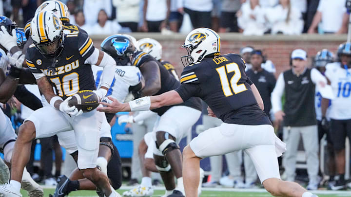 Sep 7, 2024; Columbia, Missouri, USA; Missouri Tigers quarterback Brady Cook (12) hands off to wide receiver Mekhi Miller (10) against the Buffalo Bulls during the first half at Faurot Field at Memorial Stadium. Mandatory Credit: Denny Medley-Imagn Images Sep 7, 2024; Columbia, Missouri, USA; Missouri Tigers quarterback Brady Cook (12) hands off to wide receiver Mekhi Miller (10) against the Buffalo Bulls during the first half at Faurot Field at Memorial Stadium. Mandatory Credit: Denny Medley-Imagn Images