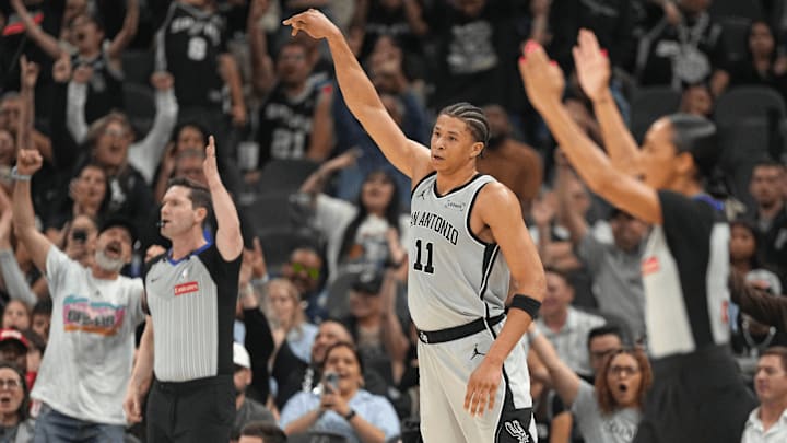 Apr 8, 2026; San Antonio, Texas, USA; San Antonio Spurs forward Carter Bryant (11) and fans react after scoring a 3-point basket during the second half against the Portland Trail Blazers at Frost Bank Center.