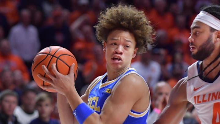 Feb 11, 2025; Champaign, Illinois, USA;  UCLA Bruins guard Trent Perry (1) drives the ball against Illinois Fighting Illini guard Kylan Boswell (4) during the second half at State Farm Center. Mandatory Credit: Ron Johnson-Imagn Images