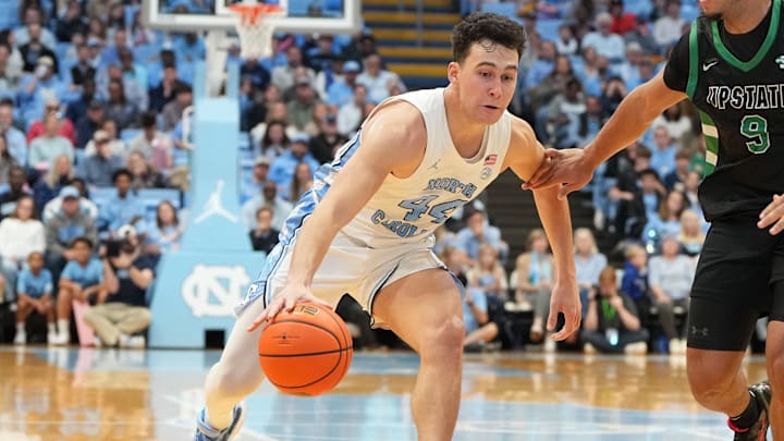 Dec 13, 2025; Chapel Hill, North Carolina, USA; North Carolina Tar Heels guard Luka Bogavac (44) dribbles as USC Upstate Spartans guard Mason Bendinger (9) defends in the second half at Dean E. Smith Center. Mandatory Credit: Bob Donnan-Imagn Images