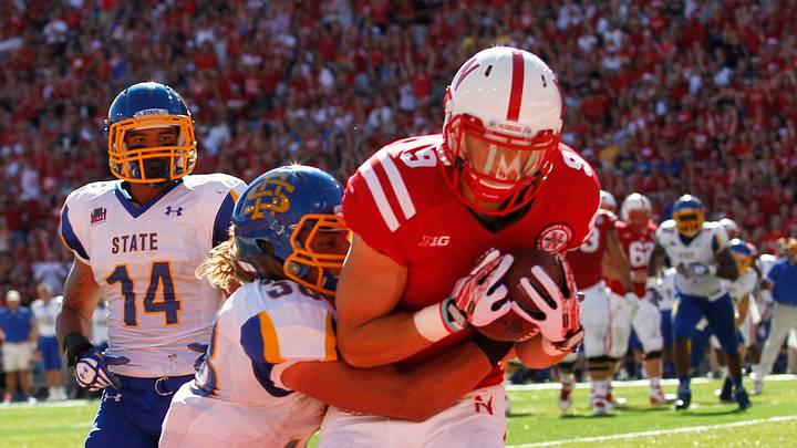 Sep 21, 2013; Lincoln, NE, USA; Nebraska Cornhuskers receiver Sam Burtch (9) catches a touchdown pass against South Dakota State Jackrabbits defender Jake Gentile (38) and Winston Wright (14) in the second quarter at Memorial Stadium. Mandatory Credit: Bruce Thorson-USA TODAY Sports Sep 21, 2013; Lincoln, NE, USA; Nebraska Cornhuskers receiver Sam Burtch (9) catches a touchdown pass against South Dakota State Jackrabbits defender Jake Gentile (38) and Winston Wright (14) in the second quarter at Memorial Stadium. Mandatory Credit: Bruce Thorson-USA TODAY Sports