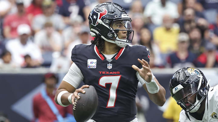 Sep 29, 2024; Houston, Texas, USA; Houston Texans quarterback C.J. Stroud (7) looks for an open receiver as Jacksonville Jaguars defensive end Josh Hines-Allen (41) applies defensive pressure during the second quarter at NRG Stadium. Mandatory Credit: Troy Taormina-Imagn Images