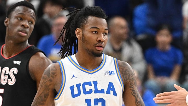 Dec 28, 2024; Inglewood, California, USA; UCLA Bruins guard Sebastian Mack (12) slaps hands with teammate Kobe Johnson (0) during a college basketball game against the Gonzaga Bulldogs at Intuit Dome. Mandatory Credit: Robert Hanashiro-Imagn Images