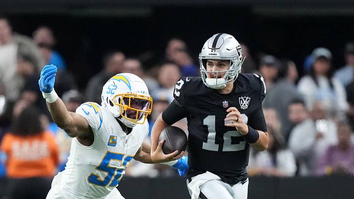 Jan 5, 2025; Paradise, Nevada, USA; Las Vegas Raiders quarterback Aidan O'Connell (12) carries the ball against Los Angeles Chargers linebacker Khalil Mack (52) in the second half at Allegiant Stadium. Mandatory Credit: Kirby Lee-Imagn Images