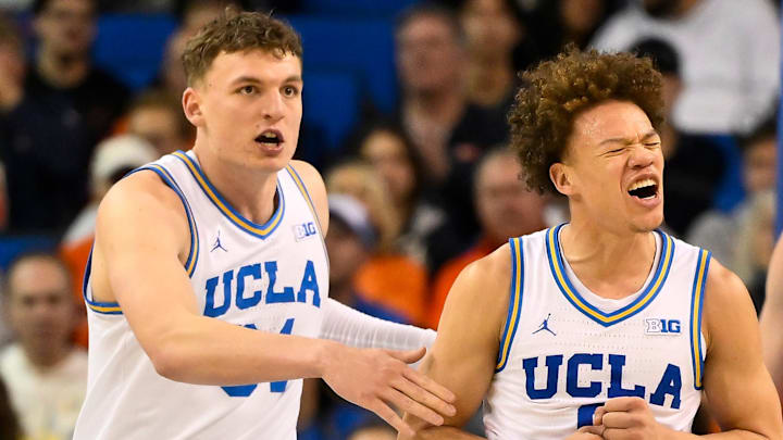 Feb 21, 2026; Los Angeles, California, USA; UCLA guard Trent Perry (0) reacts to scoring against Illinois during the second half while UCLA forward Tyler Bilodeau (34) (left) and Illinois center Tomislav Ivisic (13) (right) look on at Pauley Pavilion presented by Wescom Financial. Mandatory Credit: Robert Hanashiro-Imagn Images Feb 21, 2026; Los Angeles, California, USA; UCLA guard Trent Perry (0) reacts to scoring against Illinois during the second half while UCLA forward Tyler Bilodeau (34) (left) and Illinois center Tomislav Ivisic (13) (right) look on at Pauley Pavilion presented by Wescom Financial. Mandatory Credit: Robert Hanashiro-Imagn Images