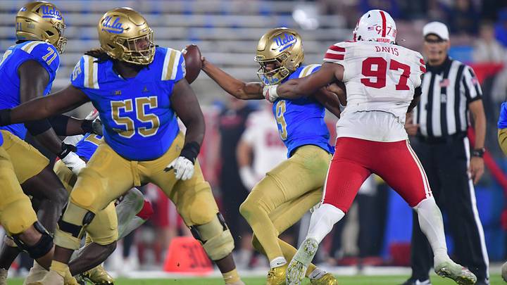 Nov 8, 2025; Pasadena, California, USA; UCLA Bruins quarterback Nico Iamaleava (9) is sacked by Nebraska Cornhuskers defensive lineman Keona Davis (97) during the second half at the Rose Bowl. Mandatory Credit: Gary A. Vasquez-Imagn Images