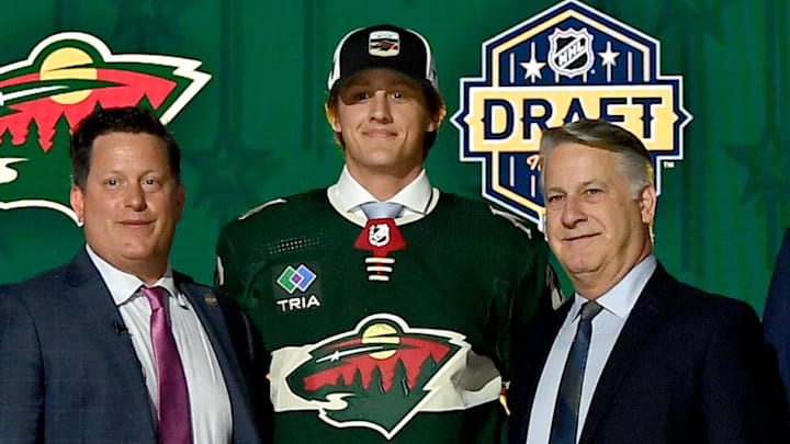 Jun 28, 2023; Nashville, Tennessee, USA; Minnesota Wild draft pick Charlie Stramel stands with Wild staff after being selected with the twenty-first pick in round one of the 2023 NHL Draft at Bridgestone Arena. Mandatory Credit: Christopher Hanewinckel-Imagn Images