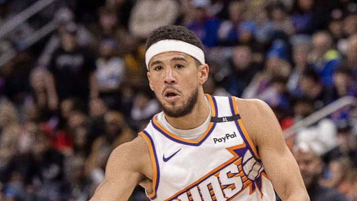Phoenix Suns guard Devin Booker passes the ball against the Detroit Pistons. Phoenix Suns guard Devin Booker passes the ball against the Detroit Pistons.