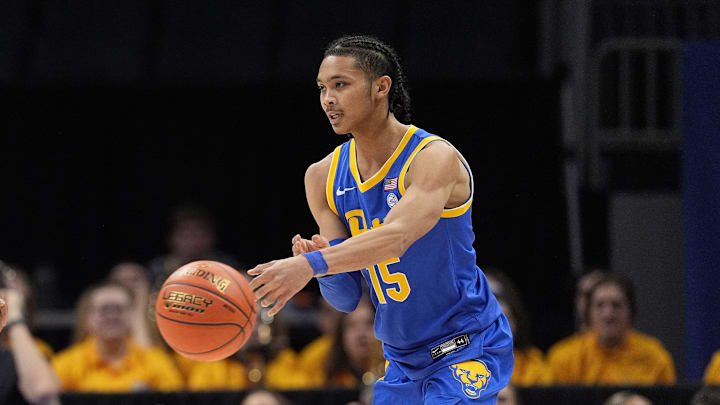 Mar 11, 2025; Charlotte, NC, USA; Pittsburgh Panthers guard Jaland Lowe (15) passes off against Notre Dame Fighting Irish guard Markus Burton (3) during the second half at Spectrum Center. Mandatory Credit: Jim Dedmon-Imagn Images